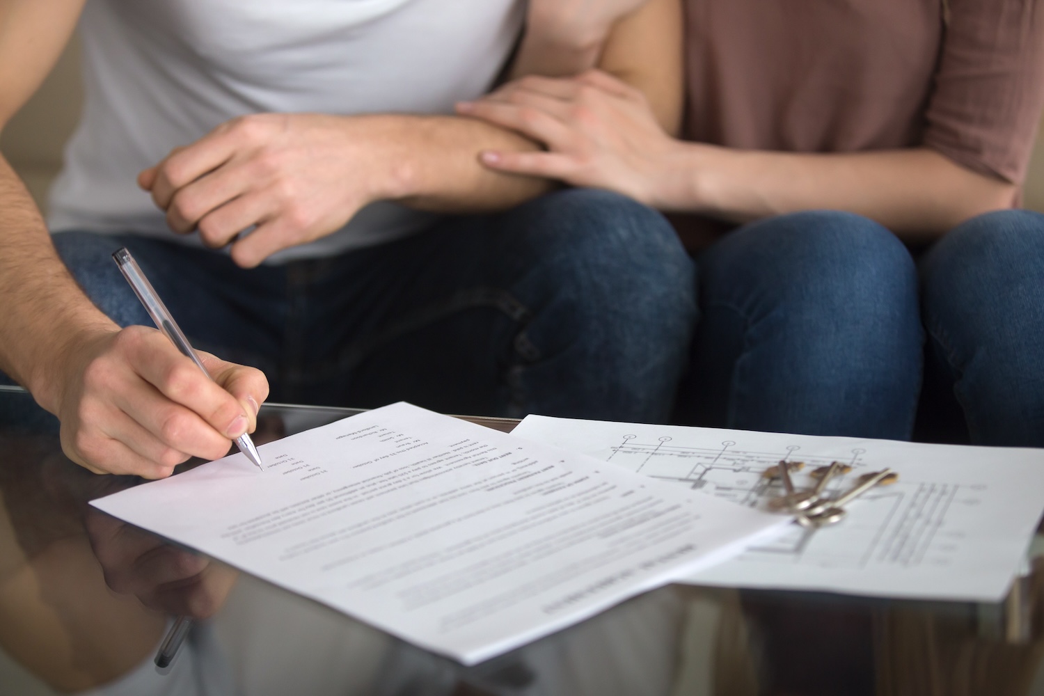 A couple reviewing property documents with a conveyancer, getting clear guidance on the home-buying process timeline.
